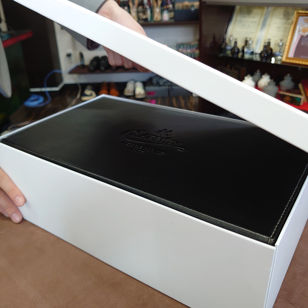 サフィールノワール デラックスハイシャインセット エックスラージを白い箱に入れる画像。