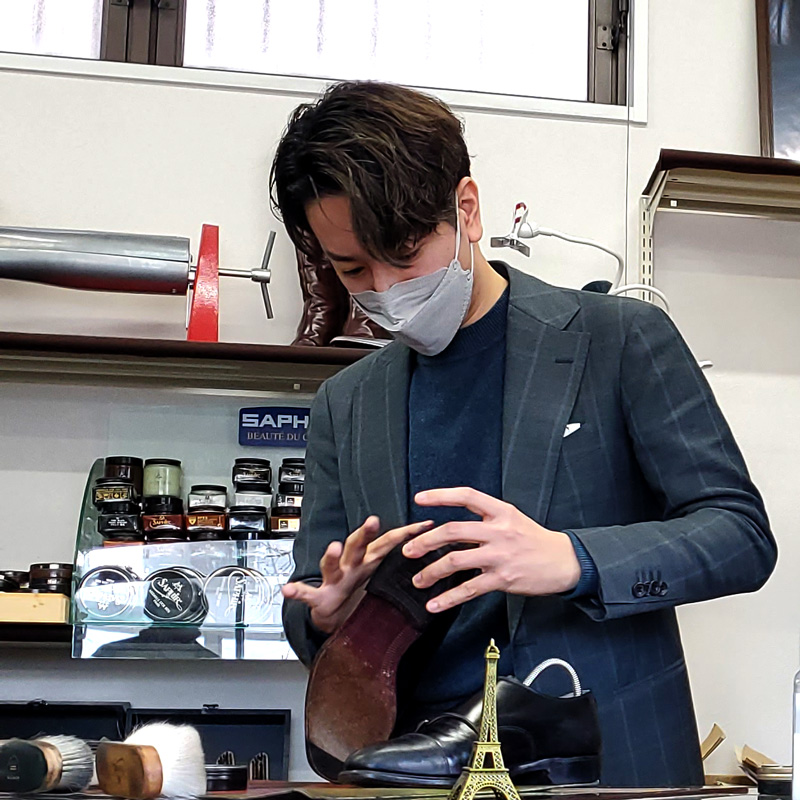 SHOESLab. TORCH 代表 松田さんが靴を磨いている写真です。