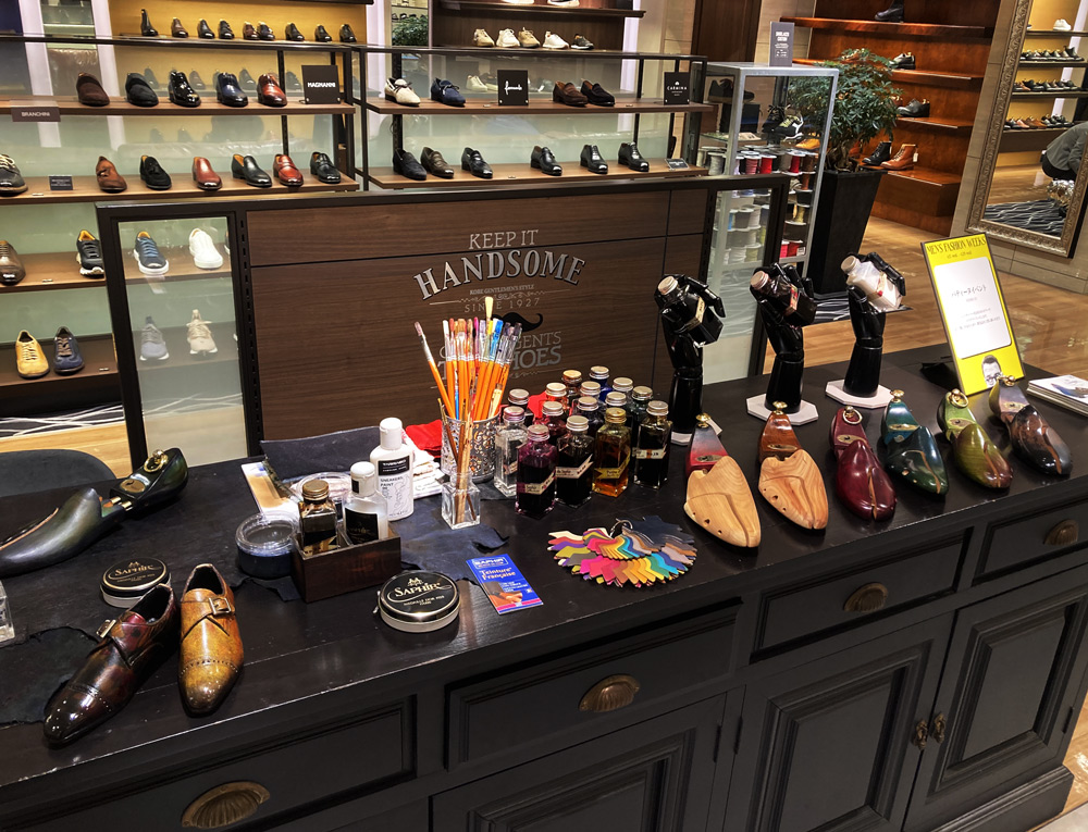 パティーヌされたシューツリーのサンプルやサフィールの染料 ダイフレンチリキッドが並ぶイベントスペース