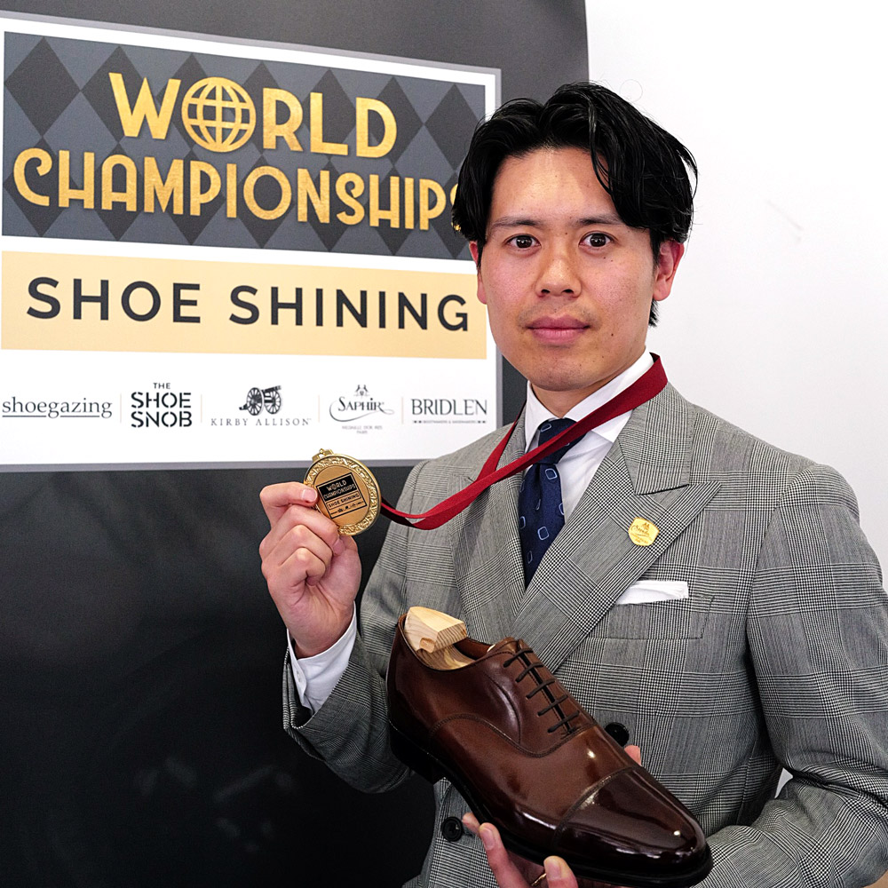 金メダルと仕上げた靴を手に喜びを表す𠮷冨さん