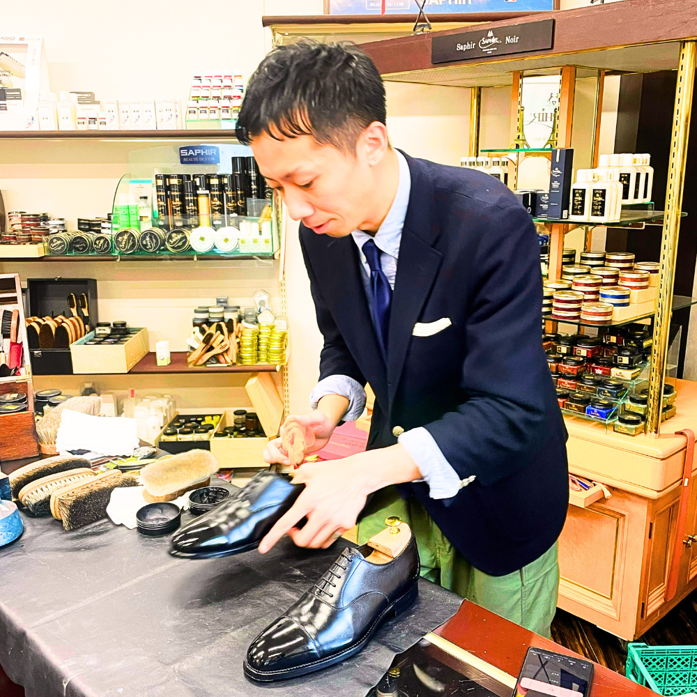 熊田靴店（東京）　遠田 智哉さんが靴を磨いている写真です。