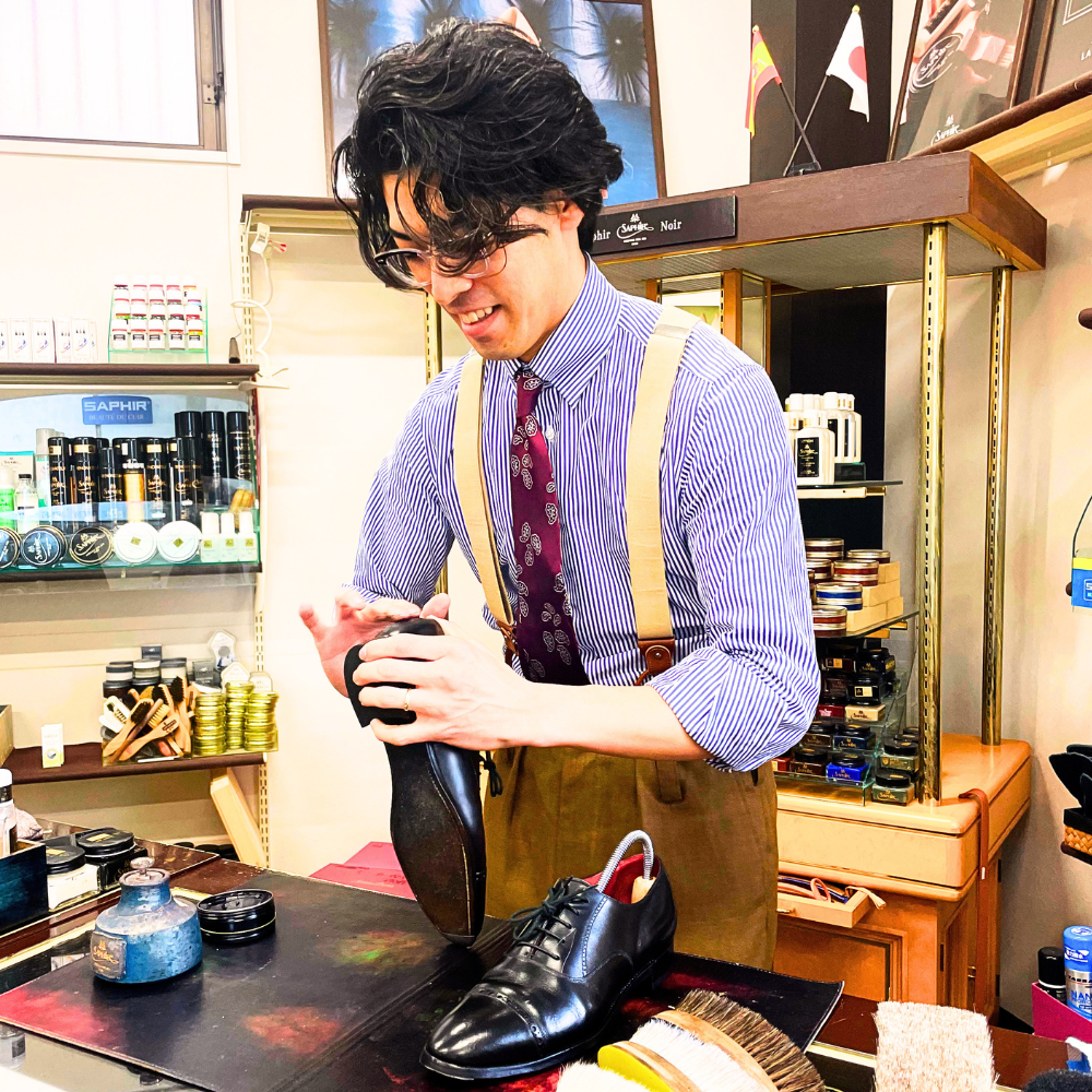 92-NINETYTWO- 村上 柊介さんが靴を磨いている写真です。